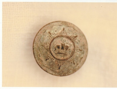 Photograph of a button from a Fencible Uniform found under Sgt Michael Ford's cottage now in Howick Historical Village.; La Roche, Alan; c1995; P2021.52.01