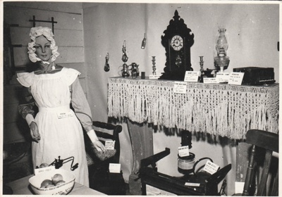 A mannequin in a kitchen at the 1962 exhibition of the Howick Historical Society in the Howick Town Hall.; N.Z. Herald; 1962; P2022.10.02