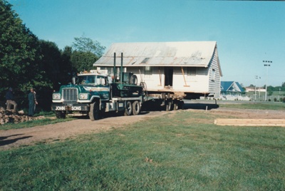 Fitzpatrick's Cottage on a transporter being moved through Lloyd Elsmore Park to Howick Historical Village. ; Smith, Christina; November 1997; P2021.79.03