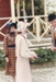 Two girls and a man, in costume standing outside de Quincey's Cottage on a Gala day at Howick Historical Village.; Healey, N; October 1985; P2021.179.03