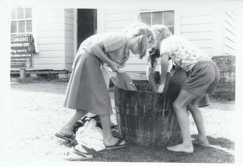 Schoolgirls learning how to wash clothes in Historical Village during a