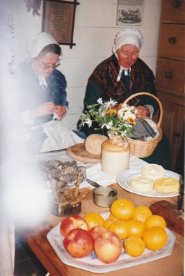 Lois Abram and another woman, in costume, sewing in Howick Historical Village.; P2021.105.15