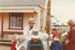 Alan la Roche (in costume) with a group of children outside Brindle Cottage In Howick Historical Village on a Live Day.; August 23-24 1980; P2021.118.03