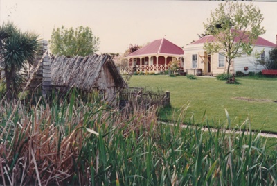 The mail runner's cottage with De Quincey's and Johnson's in the background at Howick Historical Village.; La Roche, Alan; P2021.83.14