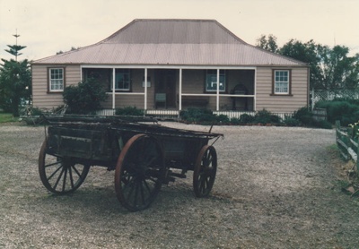 A wagon in front of Eckford's homestead in the Howick Historical Village.; La Roche, Alan; August 1988; P2021.08.10