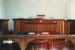 The interior of the Howick Court House in the Howick Historical Village showing the wooden table, chairs and the bench.; Harris, Josie; P2021.16.11
