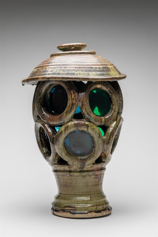 Lantern with green and blue coloured circular glass. The overall body is constructed both with turned and sculptured features.