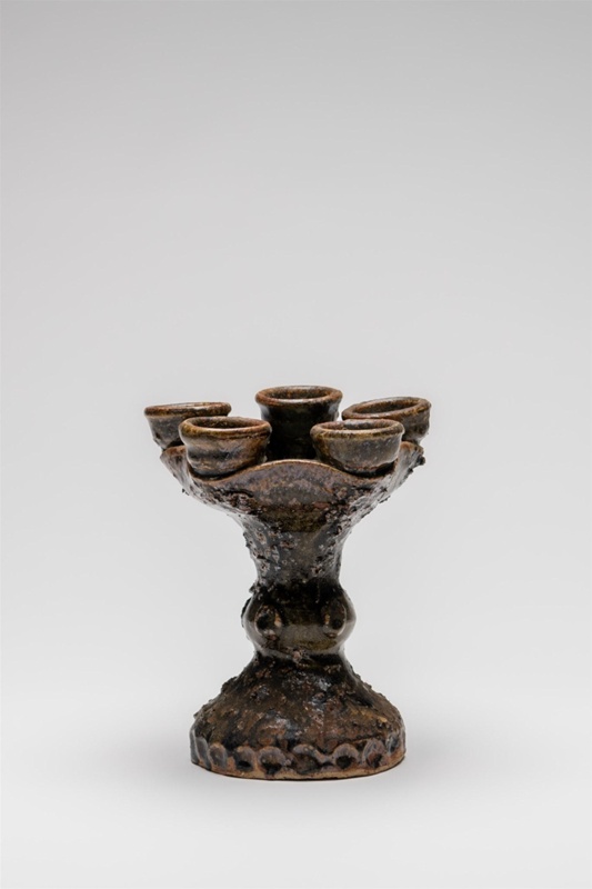 Five arm candelabra. Rough textured surface, with green molten glass detail interior base.