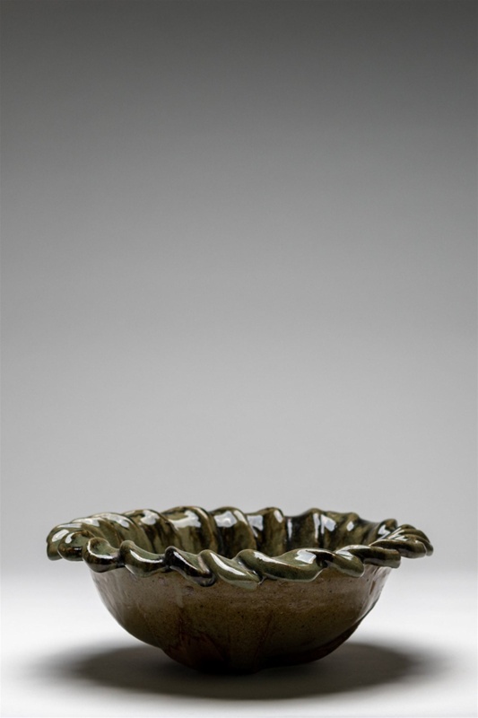 Heavy bowl with petal like sculptural detail around the lip and temuka inspired glaze.