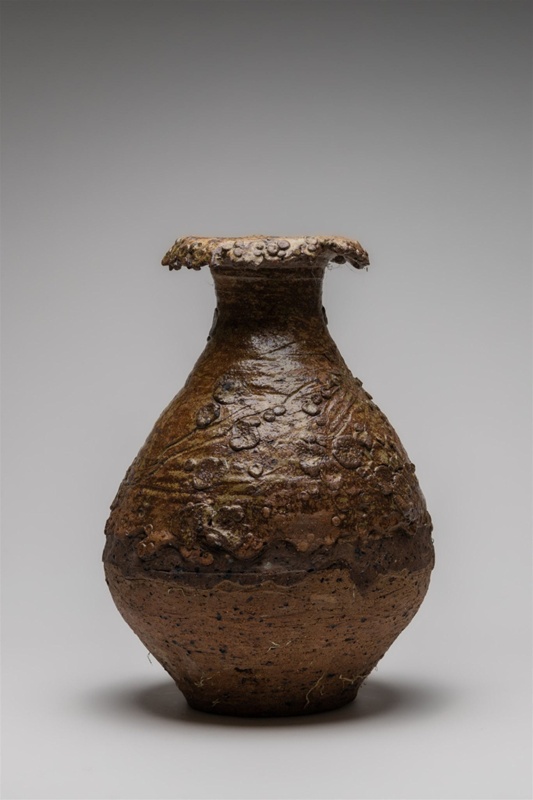 Floor vessel featuring prominent lip with a layered clay surface. This vessel is heavily textured with visible grog added and attached sculptured detailing.