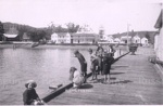 Photo: Children fishing on Russell wharf with Clows' boarding house and Duke of Marlborough hotel in background, prior to 1931 fire ; 03/113