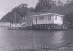 Photo: Museum curator's cottage arriving by barge at Matauwhi Bay; 97/1074