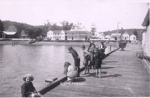 Photo: Children fishing from Russell wharf. Waterfront buildings are from Bellgrove to Baker's store.; 97/894