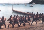 Photo: Waka on Russell Beach, paddlers performing a haka, c1980's; 97/1681/4