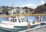 Postcard: "Wairoa" at Russell wharf, waterfront in background, c1960's; 07/23