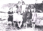 Photo: Group. Back row: Janey Kydd, Mabel Saunders, Ella Kydd, Hazel Fuller, Hannah Kydd. Front row: Wai Anglem-Hardcastle with Glen Hodgson on knee, Topsy - , Hazel Forsythe, Mavis - . 1916; 01/218
