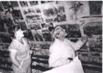 Photo: Paula Gill and Marie King looking at newspapers lining the attic wall, Russell Police station, 1983.; 97/803