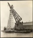 Photograph: Floating crane upending pile driver frame, 1913.; Auckland Harbour Board. Engineer's Dept.; 2010.132.228