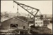 Photograph: Floating crane lifting half of old Shed 40 from Hobson Wharf to Western Wharf, 1923.; Auckland Harbour Board. Engineer's Dept.; 2010.132.269
