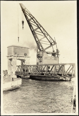 Photograph: Crane lifting the Portal House from the north wall to the Portal, Western Vehicular Ferry Landing, 1929.; Auckland Harbour Board. Engineer's Dept.; 2010.132.185