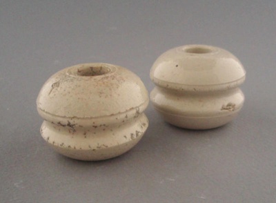 Two bobbin insulators; Crown Lynn Technical Ceramics Limited; 1930-1965; 2009.1.1293.1-2