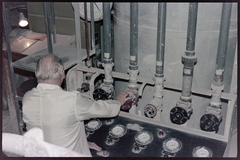 Negative - Man working at bank of vertical pipes with dials corresponding to each; 1960s; 2008.1.3084