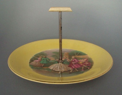 Cake plate and handle - dancers; Crown Lynn Potteries Limited; 1950-1970; 2008.1.560.1-2