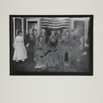 [Untitled, thirteen adults and two children sitting in front of the American flag] ; Wells, Alice; c.a. 1960s; 1976:0025:0002