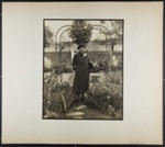 [woman standing under arbor in garden with coat and beret]; Hahn, Alta Ruth; ca.1930; 1982:0020:0022