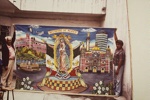 [Artist Jacinto Rojas with son Juan de Dios holding up & backdrop they just painted for use at the Shrine of Guadalupe, Mexico City, Mexico].; Oettinger, Marion; 1989; 2009:0058:0002