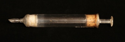 Pig dosing syringe in box; STMEA:75.A.58.12c