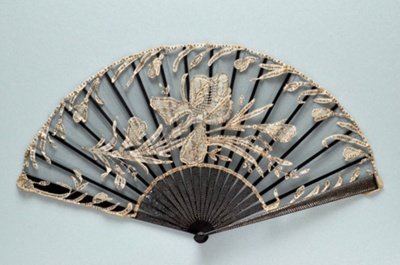Black folding fan with black machine net leaf applied with bobbin lace.   Sticks inset with sequins. France, c. 1890; LDFAN2014.32