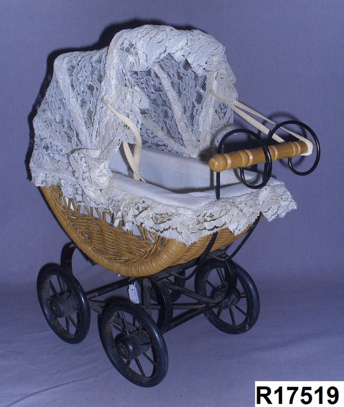 Small toy doll's pram, with a lace folding hood. The body has woven cane sides a... eHive