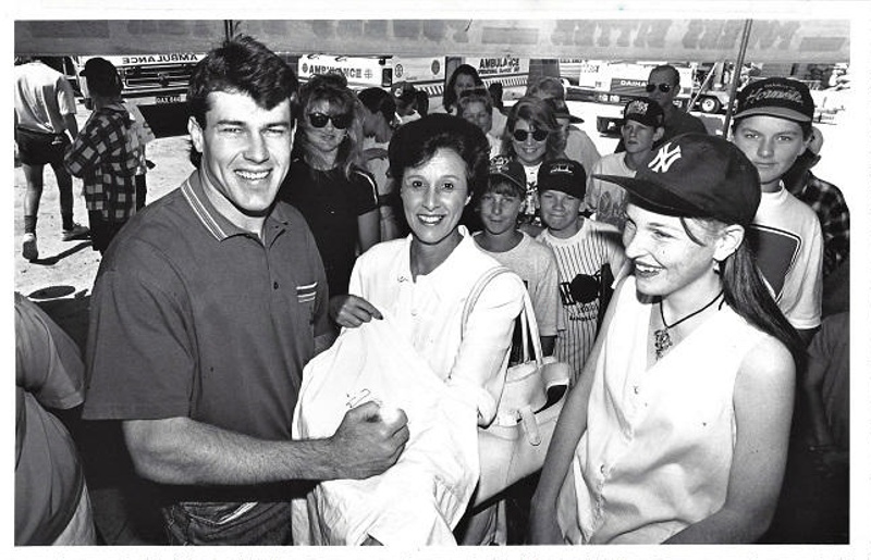 Photograph of Willie Carne signing autographs, at the opening of