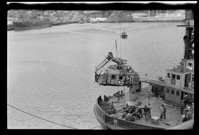 The remains of a US helicopter being lifted out of the water by crane ...