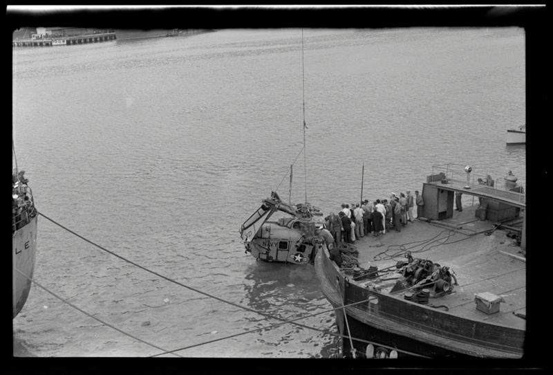 The remains of a US helicopter being lifted out of the water by crane ...