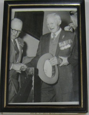 Black& white print of George Patrick Rauchle been helped down stairs by William Edwin Agland MBE.; OWM2015/99