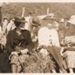 Photo, Three women and one man sit at beach; 1943; RAP2020.0008