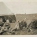 Photo, Four men in military dress lie posed before tent; RAP2020.0135