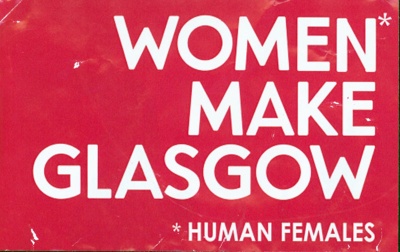 Pink sticker reading Women Make Glasgow. The word Woman is marked with an asterisk, referencing the words Human Females below.