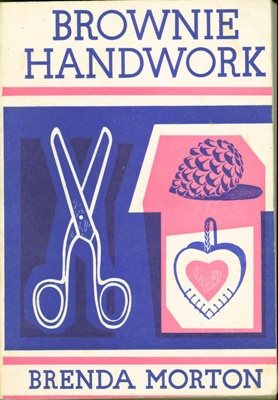 Front cover of "Brownie Handwork" book, featuring a pair of scissors and craft materials