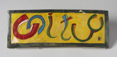 Rectangular plaque made by Gheni York bearing the word Unity in bright colours