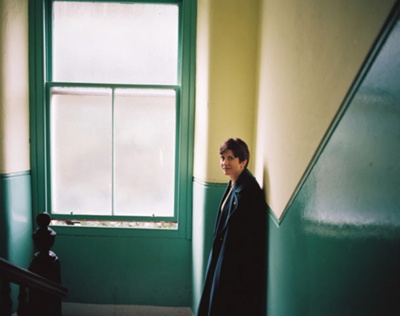 Photograph of Alison Thewliss MP standing by the window in a Glasgow tenement stairwell
