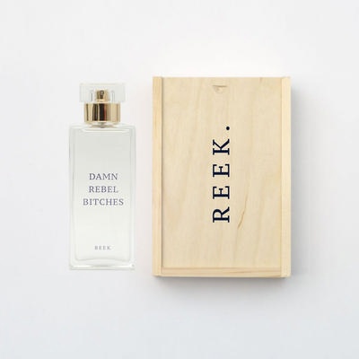 Bottle of DAMN REBEL BITCHES eau de parfum with wooden REEK perfume packaging