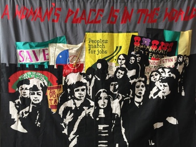 Banner titled 'A Woman's Place Is In The World' (1987) by Clare Higney