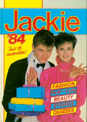 Front cover of Jackie Annual '84, featuring a heterosexual couple beside the tagline "Full of surprises!" and promising Fashion, Pop, Fun, Beauty, Stories and Quizzes inside. 