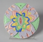 Round clay plaque painted in pastel colours by Gheni York (2002)