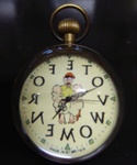 Anti-suffragette clock with depiction of a tired, angry man holding two babies on his knees