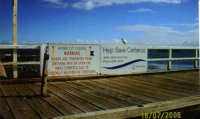 Hazard and Save the Cerberus signs on Black Rock pier; 2006; P5629