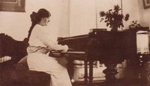 Louise Schmidt playing a grand piano in the Hampton Hotel; c. 1914; P0308